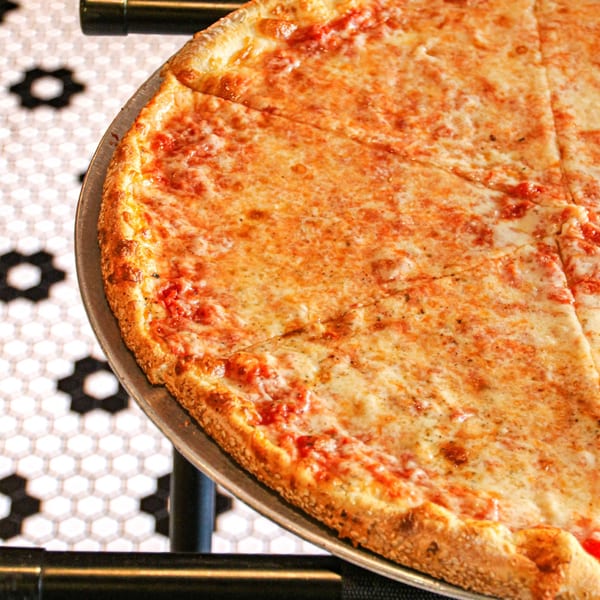 A large, cheesy pizza with tomato sauce and a golden crust, sliced and ready to eat.